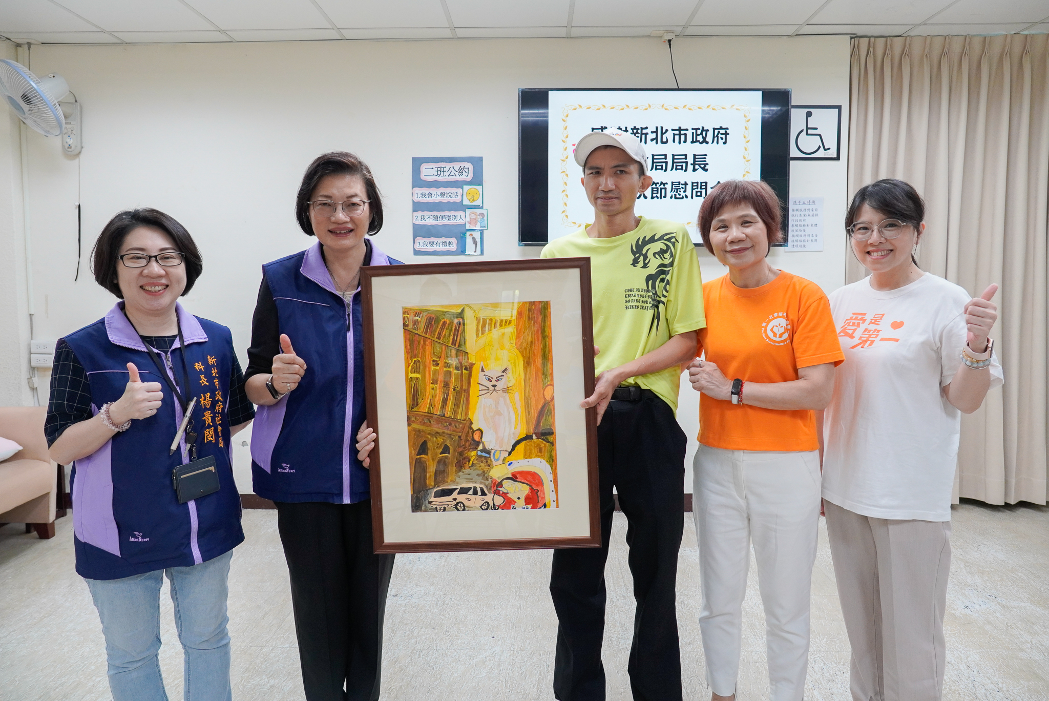 新北社會局長李美珍慰訪愛兒等7家機構 代表市長致贈秋節加菜金及蘋果 11 李美珍在慰勞崇愛發展中心時中心特別回贈由呂俞賢學員右3彩繪作品城市之王